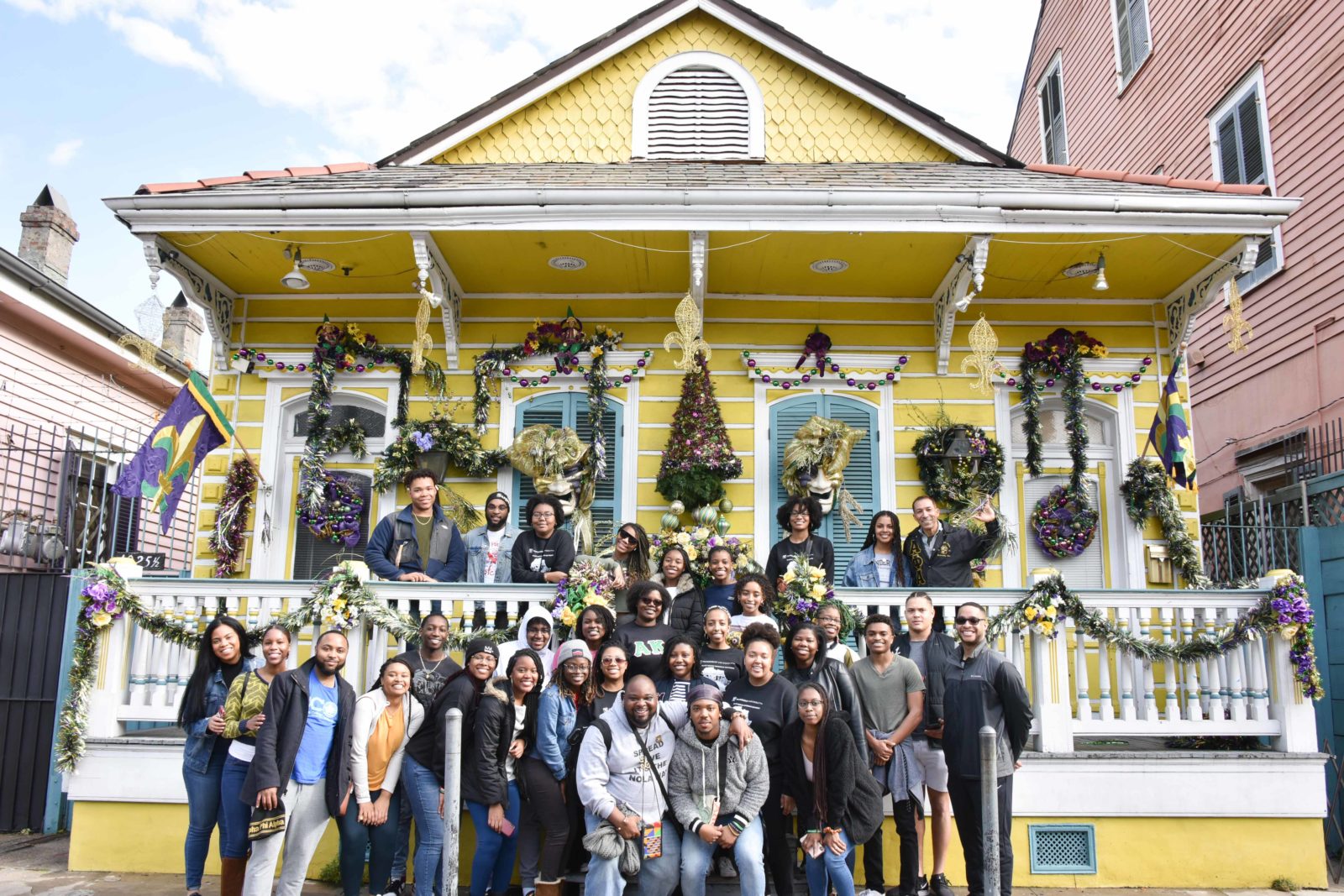 Students on the Black History Immersion Excursion standing in front of a home in the French Quarter decorated for Mardi Gras (Rosevelt Noble/Vanderbilt)