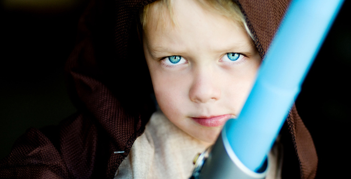 Little boy dressing up as a fictional Jedi character. Focus on eyes.