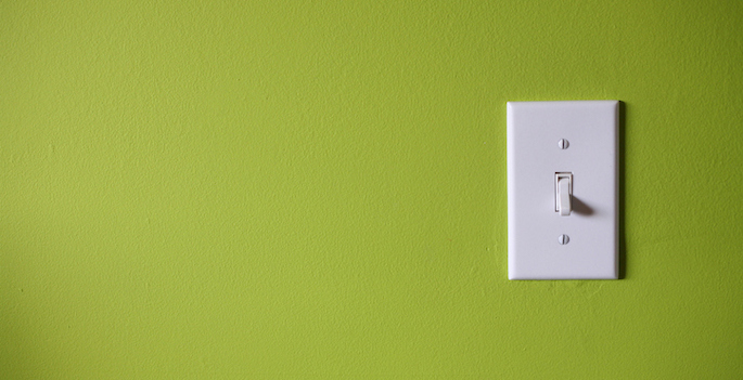 white light switch mounted on green wall