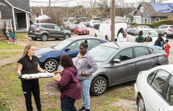 photo of students distributing supplies in neighborhood damaged by tornadoes