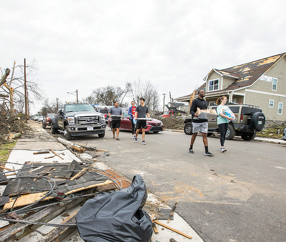 photo of students distributing supplies in neighborhood damaged by tornadoes