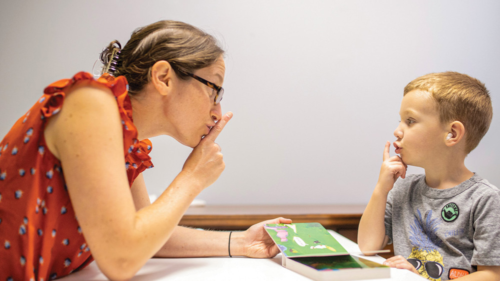 photo of Miriam Lense reading to a young boy