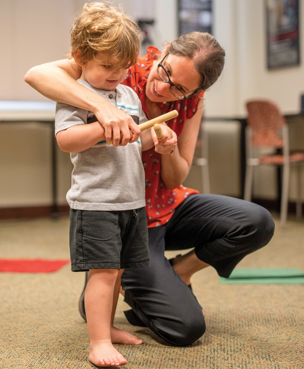 photo of Miriam Lense teaching rhythm to a young boy