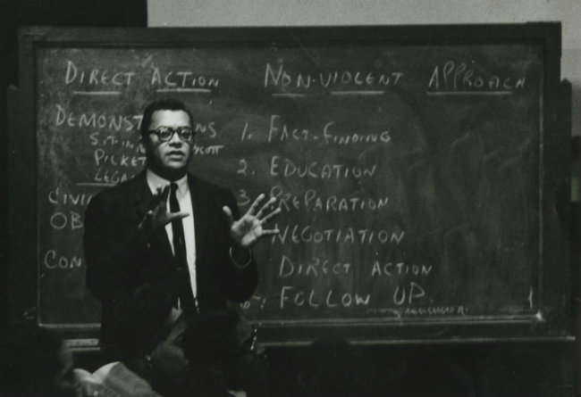 photograph of James Lawson as young man wearing suit and tie and in front of blackboard