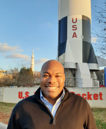 rocket scientist Patrick Taylor in front of rocket at U.S. Space and Rocket Center