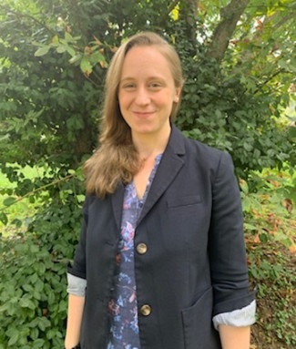 environmental photograph of Erin J. Parks in front of green shrubbery