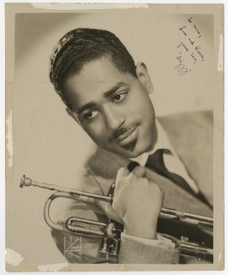 publicity headshot from the 1950s of prominent jazz musician Dizzy Gillespie holding trumpet 