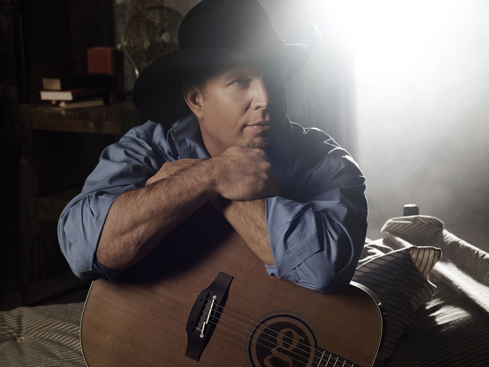 photograph of musician Garth Brooks in blue shirt with guitar