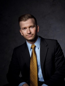 man wearing black suit, yellow tie, and blue collared shirt