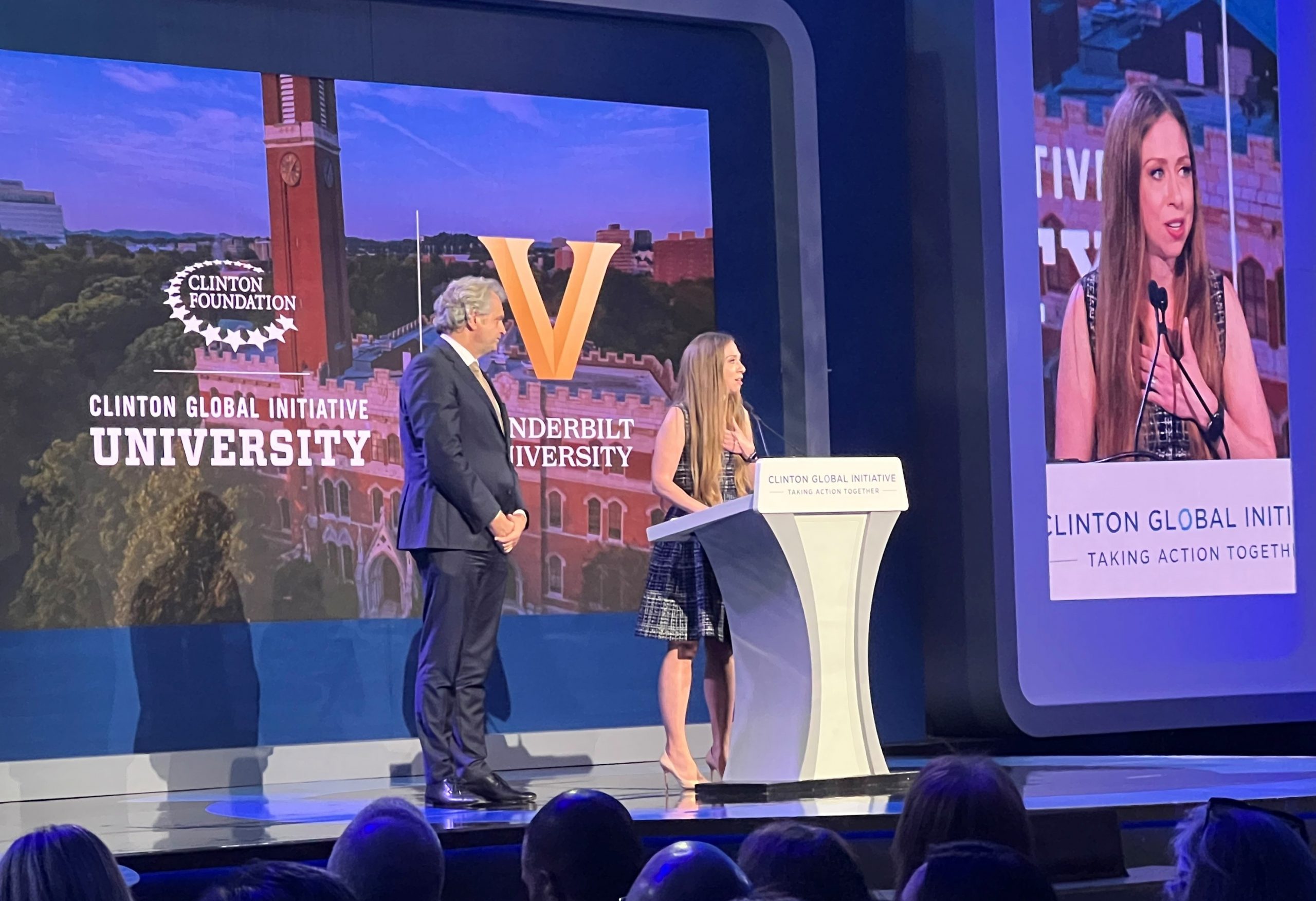 Chancellor Daniel Diermeier stands on stage at the 2022 Clinton Global Initiative meeting with Clinton Foundation Vice Chair Chelsea Clinton