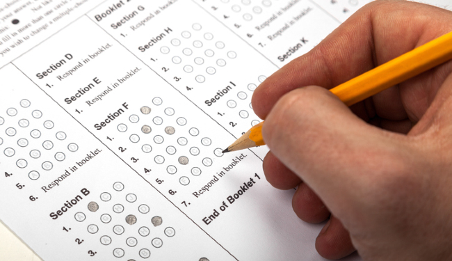 Male Hand Filling out Answers with Pencil on a Multiple Choice Test