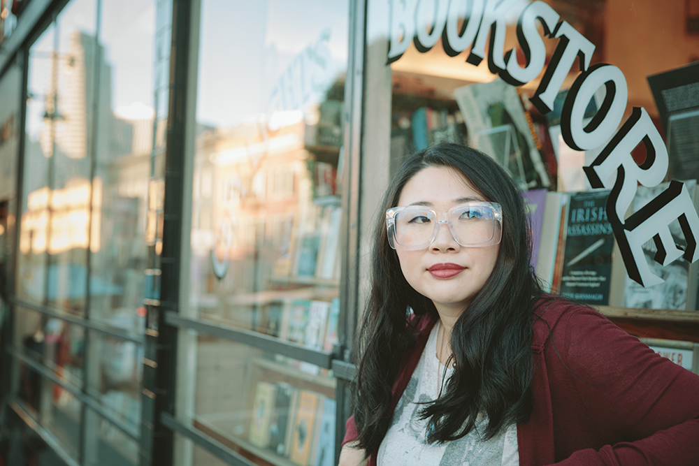 Jenny Qi standing in front of a bookstore window