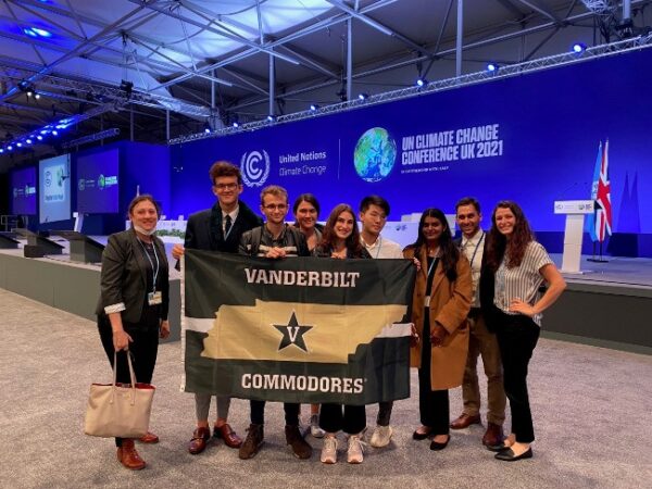 Assistant Professor Leah Dundon with Vanderbilt students at climate change negotiations in Scotland hold Vanderbilt banner