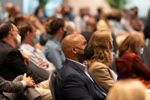 photograph of masked faculty sitting in Student Life Center Ballroom