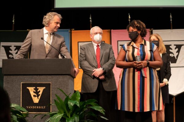 photograph of Chancellor Diermeier at podium congratulating award winner Renã A.S. Robinson