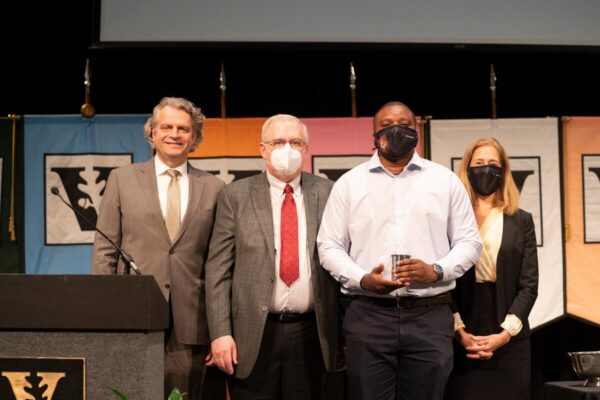 photograph of award winner Justus Ndukaife with Daniel Diermeier, Mark Magnuson and Provost Cybele Raver