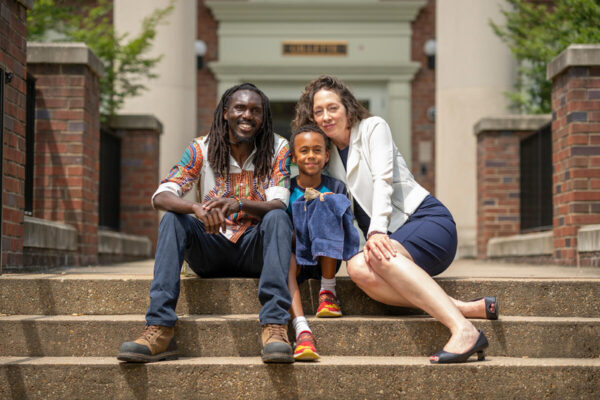 Carol Ziegler, Faculty Head of Gillette House, with her family Kipkosgei Magut, left, and Ezra Magut and pet lizard Stripes outside Gillette House on the Martha Rivers Ingram Commons.
