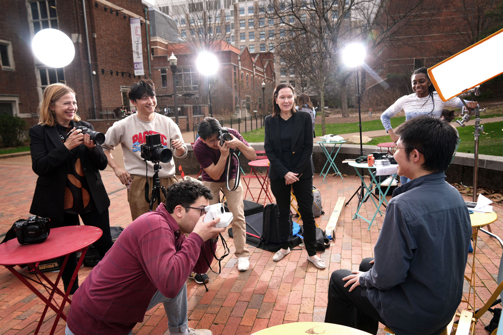 Four students, a faculty member and staff member take photos of Vanderbilt community members outside the Jean and Alexander Heard Libraries Central Library for a Vanderbilt Sesquicentennial Grant Project