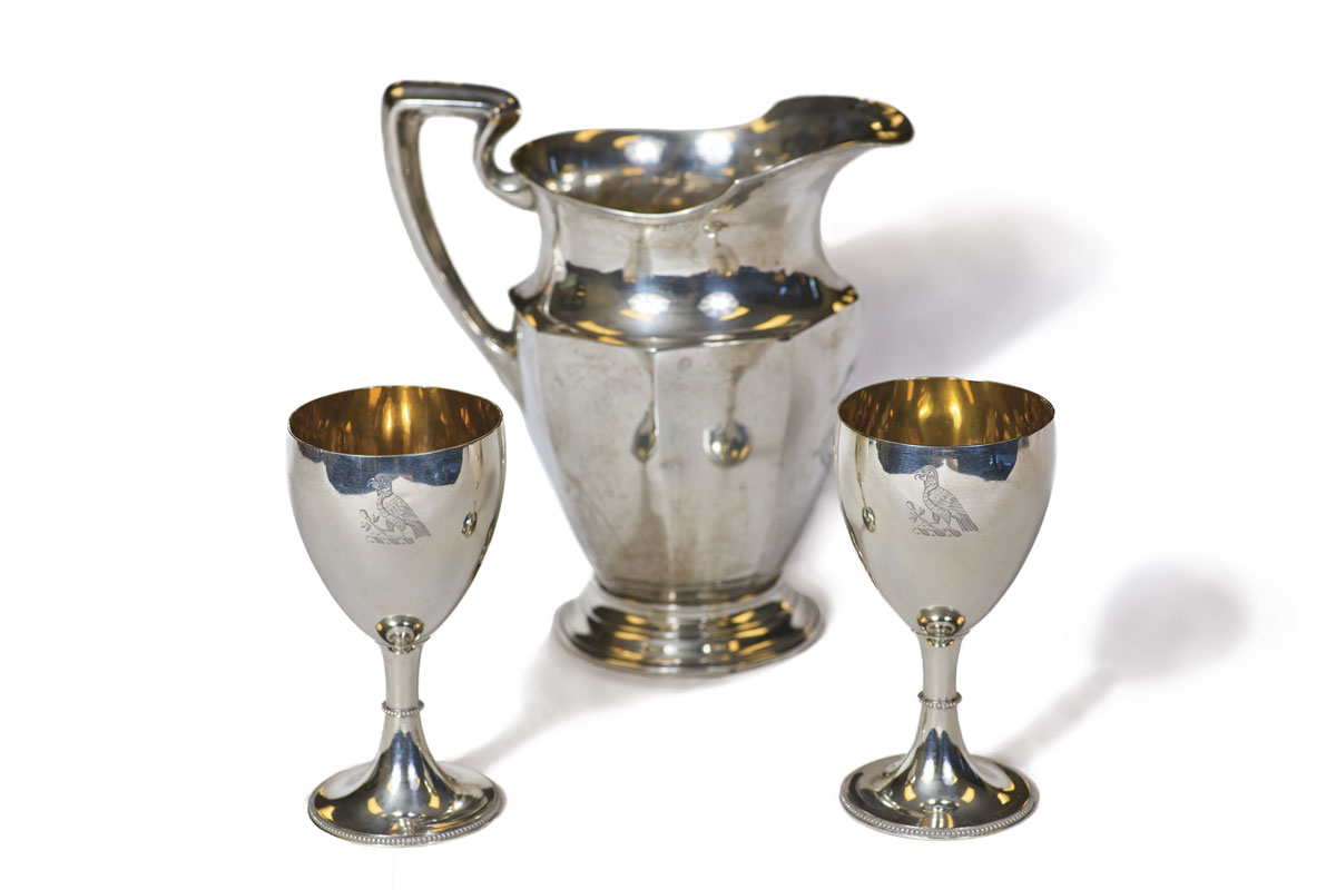 A silver pitcher and two silver goblets