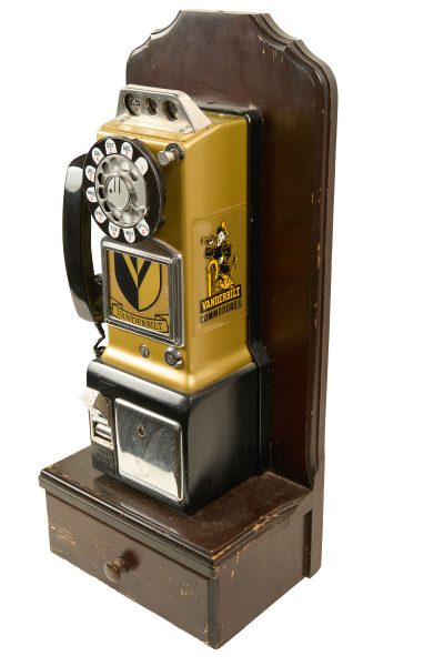 Wall telephone in black and gold with an old VU logo on it that used to be in a dorm on campus, now in University Archives