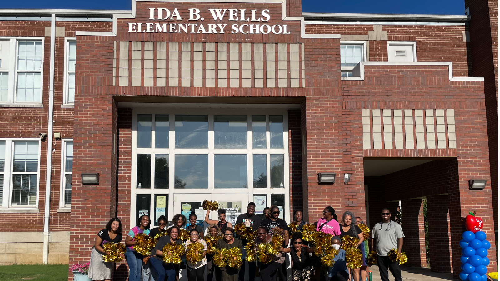 Vanderbilt students, faculty and staff greeting students in front of Ida B. Wells Elementary.