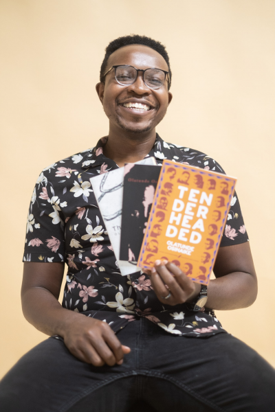Portrait shot of Olatunde Osinaike holding poetry books; photo by Jeremy Howard