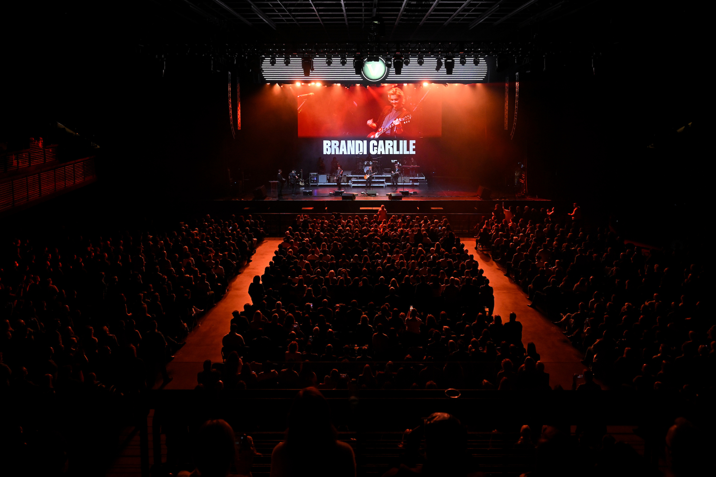 An overhead shot of a darkened auditorium with a seated crowd