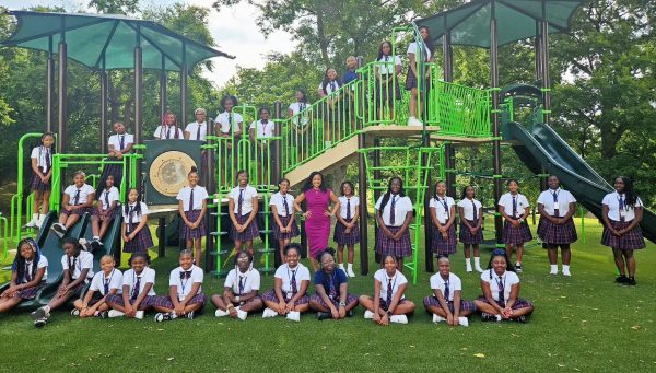 Group of students sit in front of playground
