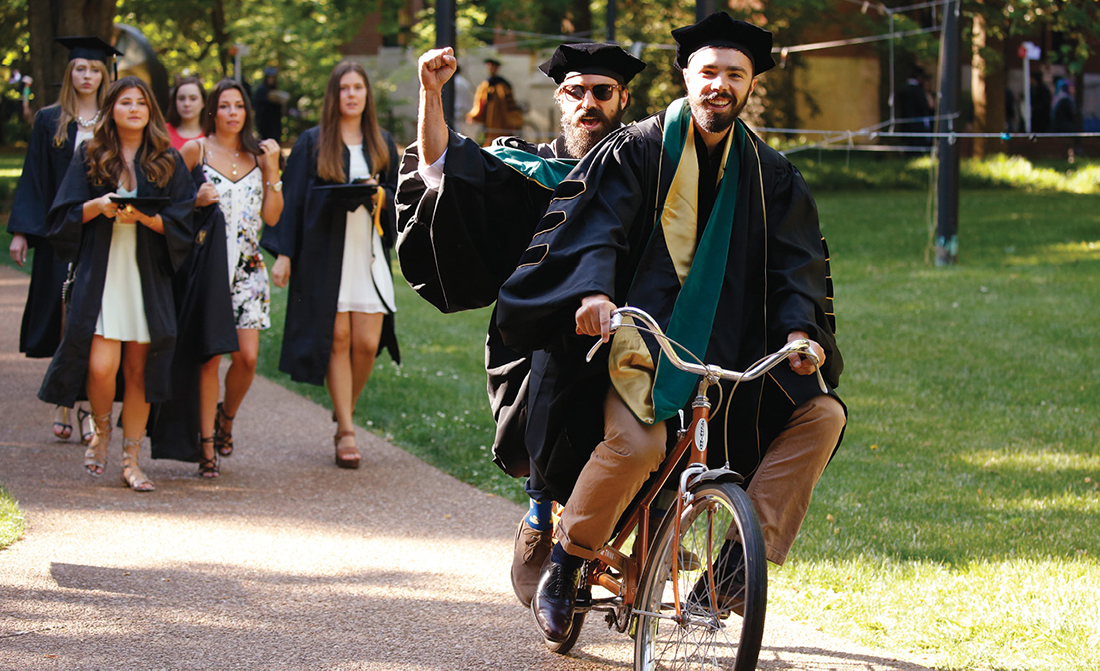 Photo of graduates on tandem bicycle