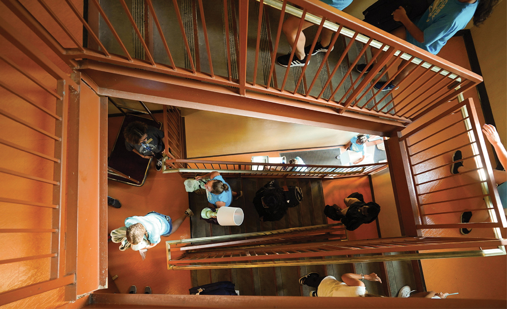 overhead view of a stairwell with students carrying their belongings