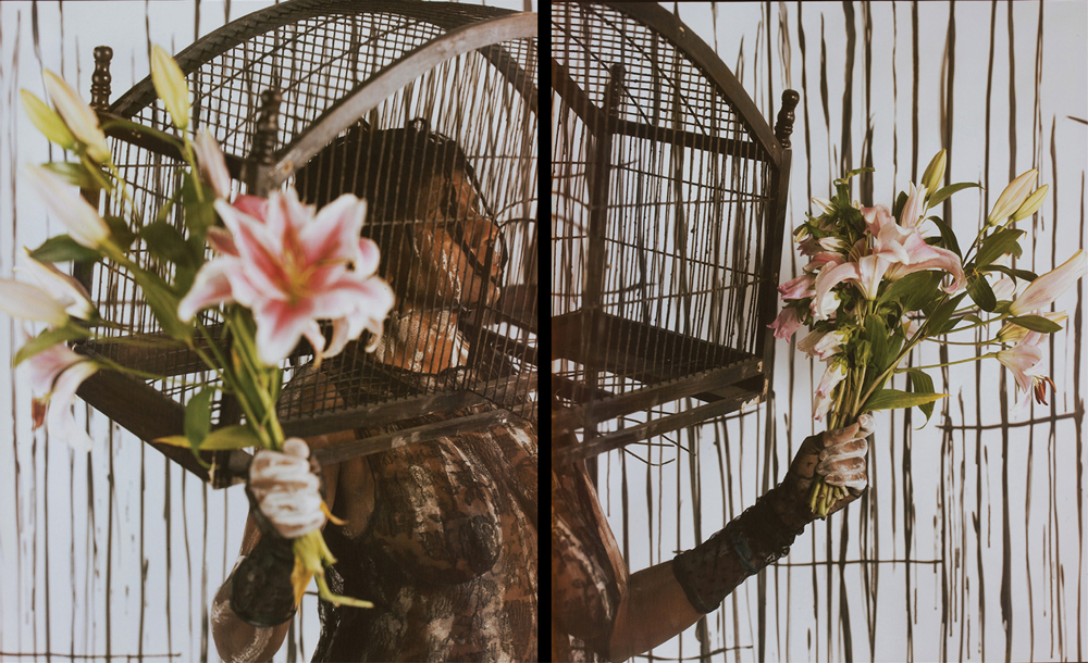 photo of Campos-Pons with her head in a birdcage and flower bouquets in each hand