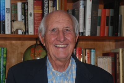 George Williamson in a suit in front of a bookcase