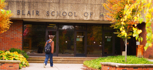 student walking into Blair School of Music building