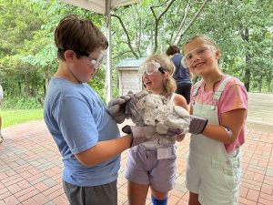 Three campers hold the comet nucleus they created.