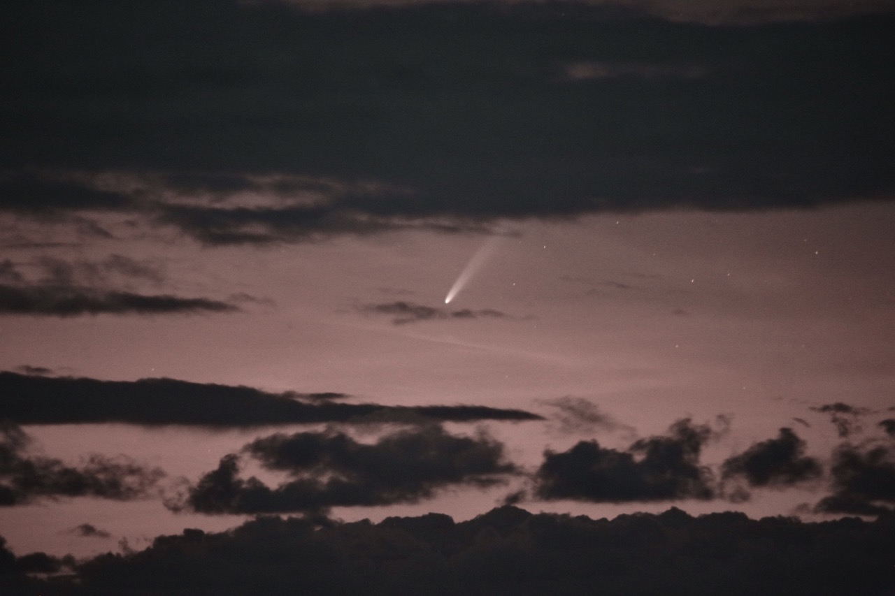 Comet C/2023 A3 ATLAS visible in a gap between clouds