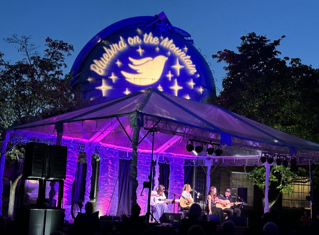 Songwriters in a brightly lit tent in front of Dyer Observatory