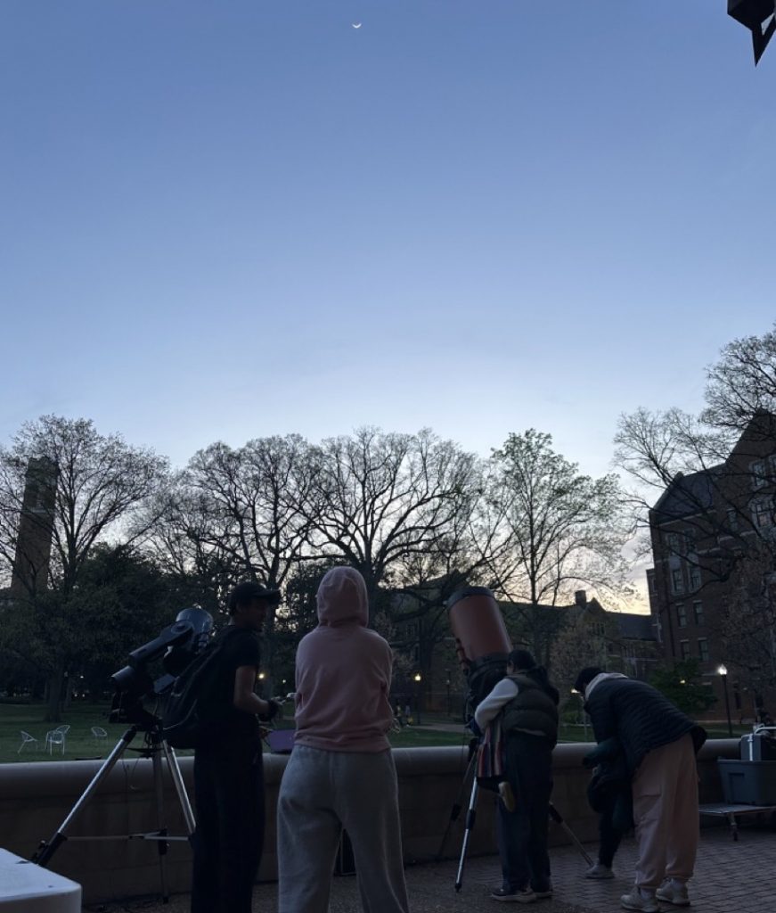 Students view the Moon and Jupiter through telescopes