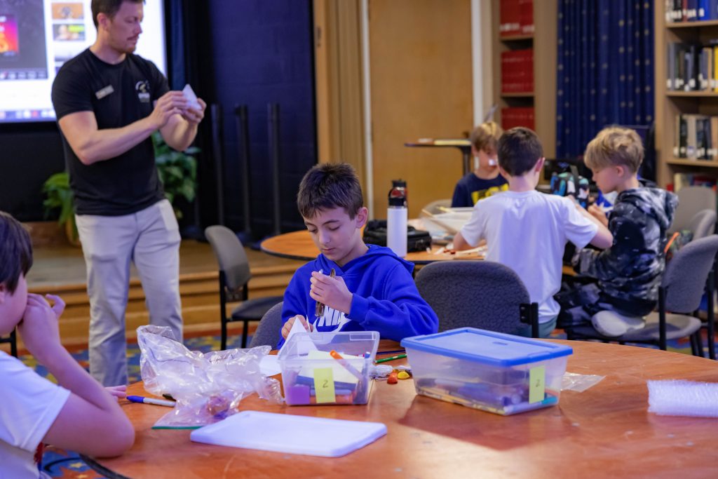 Students create model Martian landers using household items to protect their egg astronaut.