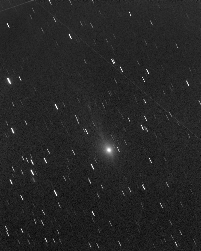 Comet 3I/ATLAS is shown against background stars that appear as streaks due to the long-exposure image following the comet.