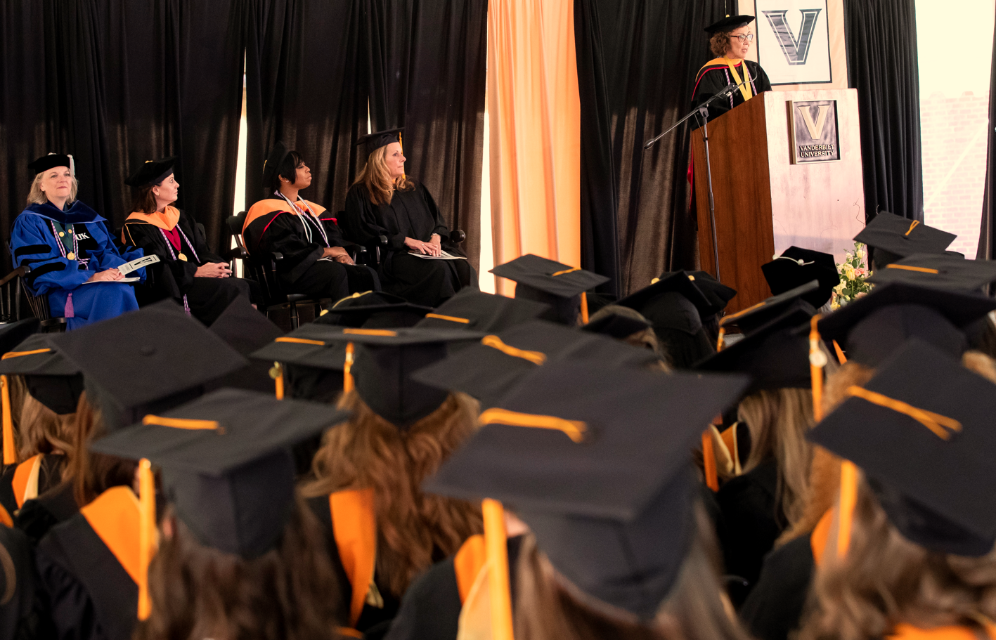 graduates watch presenter on stage