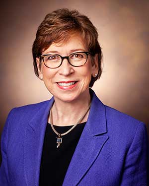 Marilyn Dubree headshot in which she wears cobalt blazer and black blouse