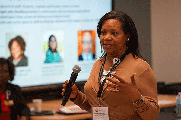 African American woman in a camel colored suit makes presentation