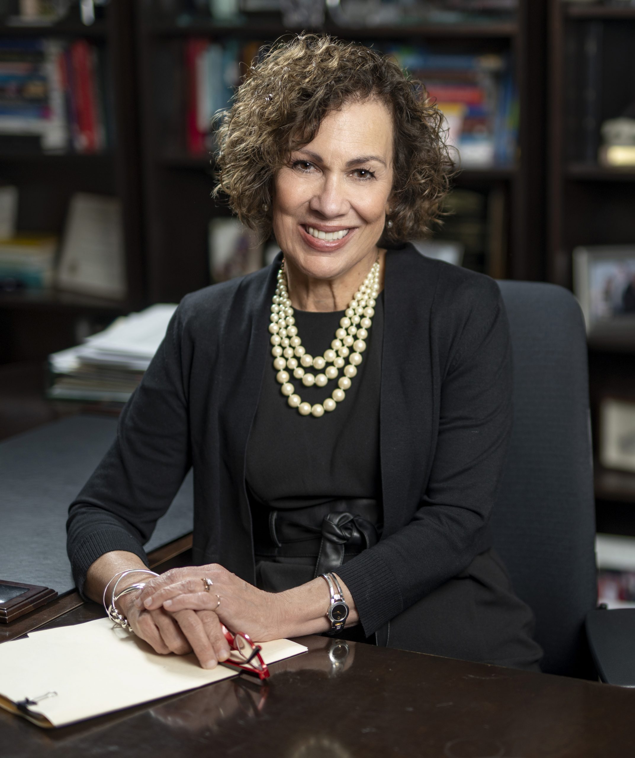 Woman sitting at desk and smiling at camera
