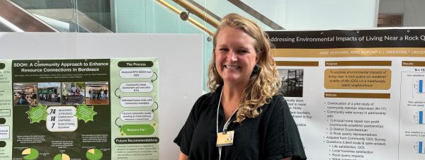 A woman smiling standing in front of a research poster.