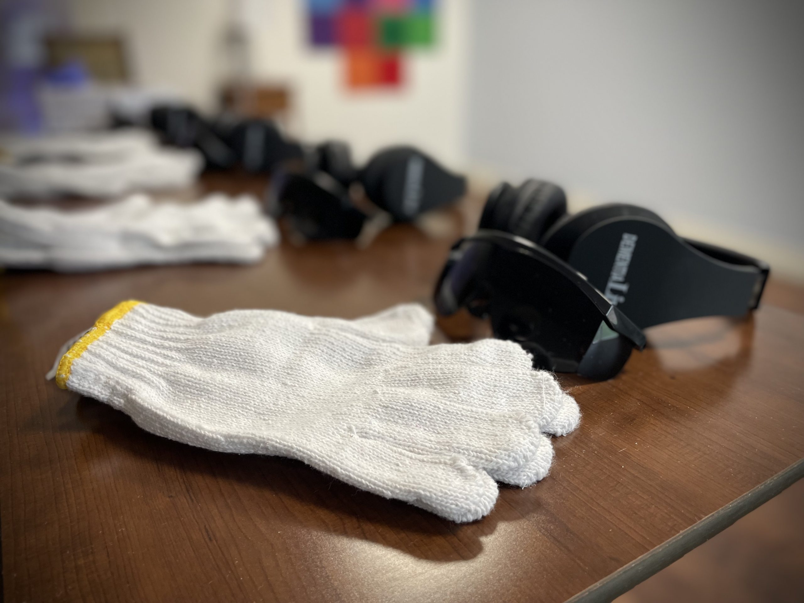 A pair of gloves, headphones and glasses sitting on a table.