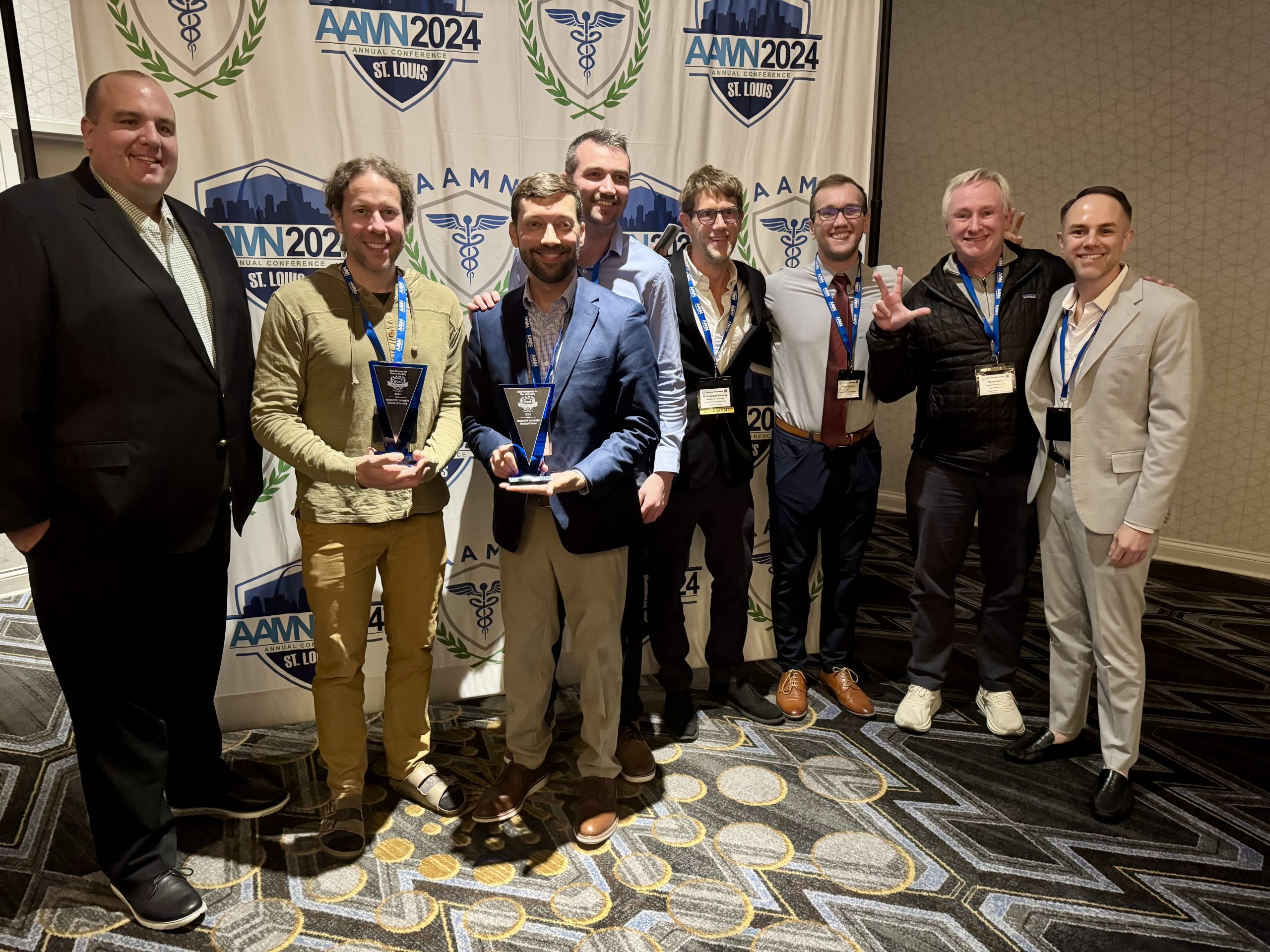 A group of men holding awards and smiling.