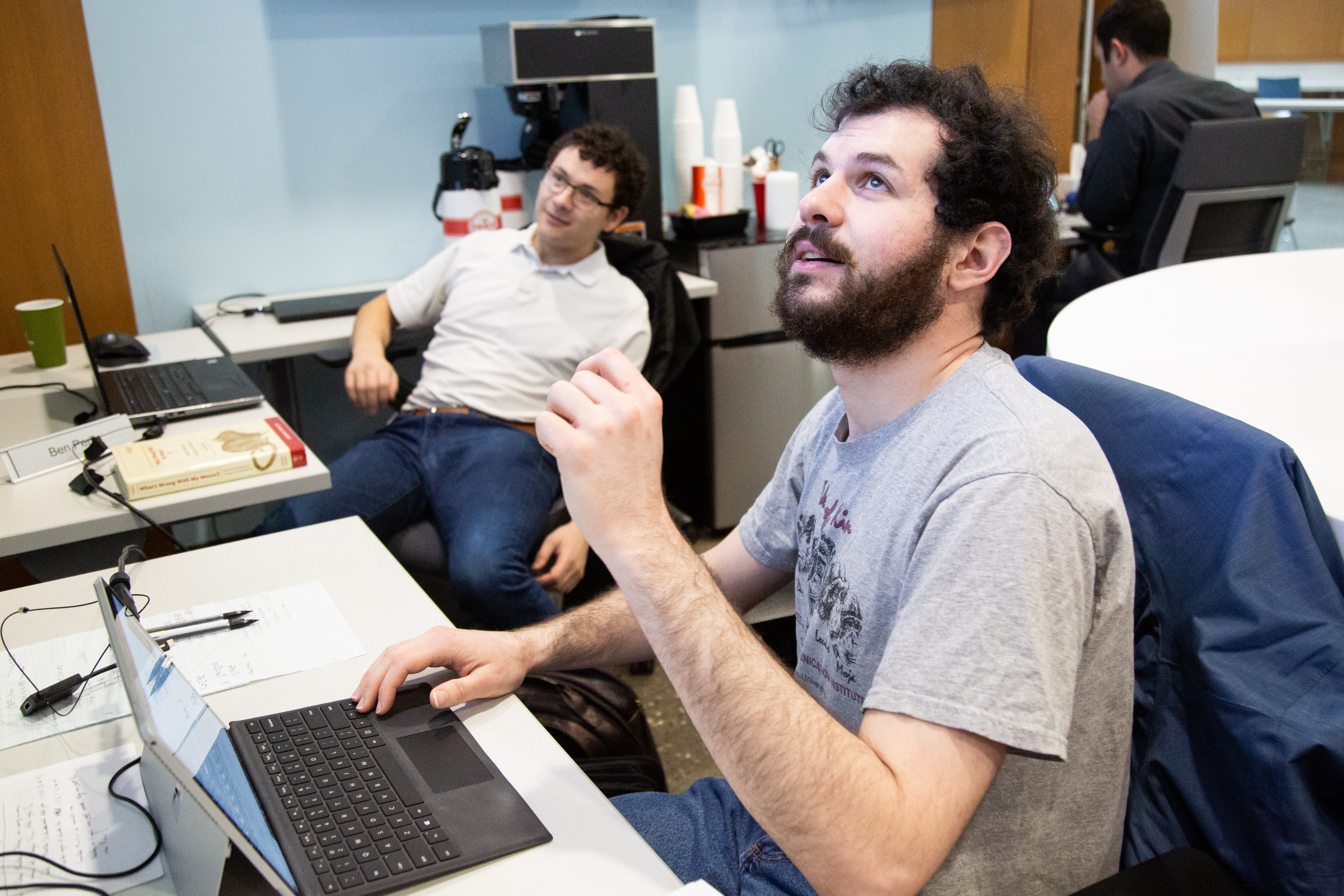 Former FCAI students Noah and Ben discuss some work appearing on one of the large collaborative screens in the center.