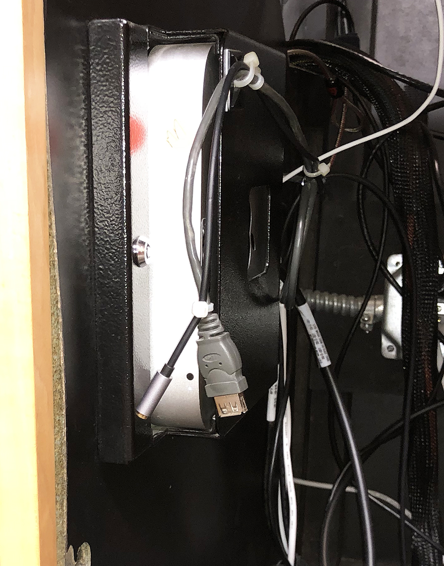 Photo of the inside of the podium where the Mac is located. A gray, female-end USB cord is hanging from a cord clip.