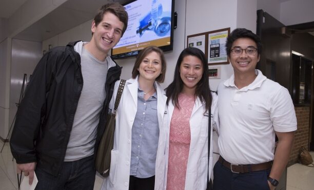 Epidemiology Ph.D. Students Lauren Saag and Jaimie Shing receive their white coats at the Simple Beginnings Ceremony.
