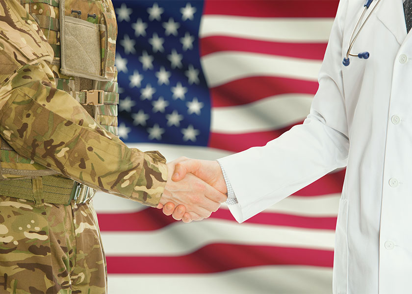 Miltary person shaking hands with medical person 